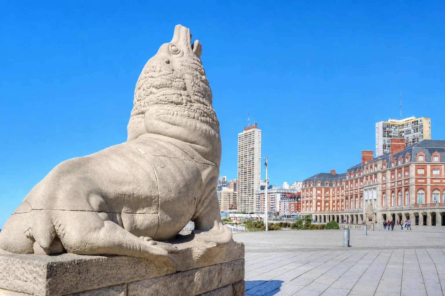 El lobo marino de piedra de la rambla, con el casino y las torres del centro detrás